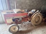 a red tractor that is parked in a barn
