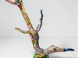 une sculpture colorée représentant un oiseau, posée sur une table