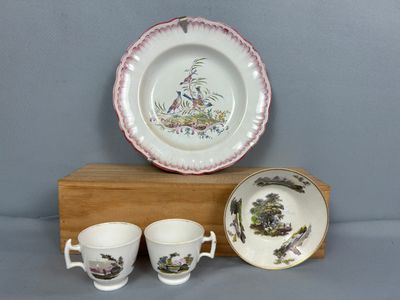 trois tasses et une assiette posées sur un support en bois
