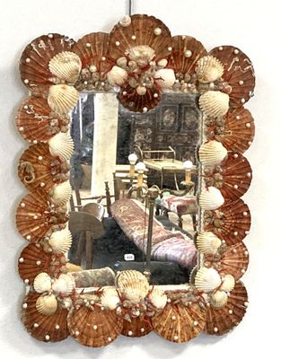 a mirror with shells on it hanging on a wall