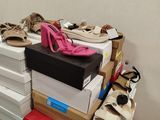 a pile of shoes on top of boxes in a room
