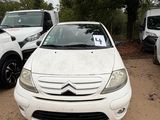 a small white car parked in a lot with other cars