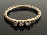 gros plan d'une bague en or et diamants sur une surface noire