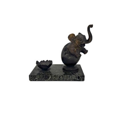 une statue d'éléphant assis sur un socle en marbre