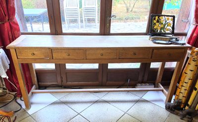 une table en bois sur laquelle est posé un ordinateur portable, devant une fenêtre