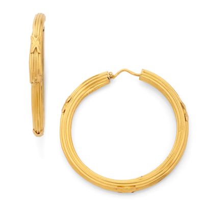 un gros plan sur une paire de boucles d'oreilles créoles en or sur fond blanc