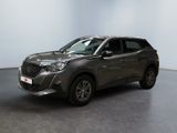 Le SUV gris est garé dans une pièce blanche au sol noir.
