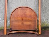 a bed with a wooden headboard and two wooden poles