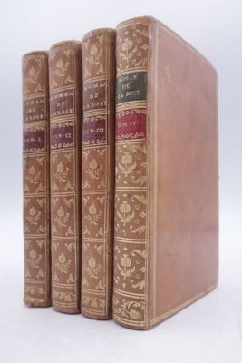 three old books are lined up on a white surface