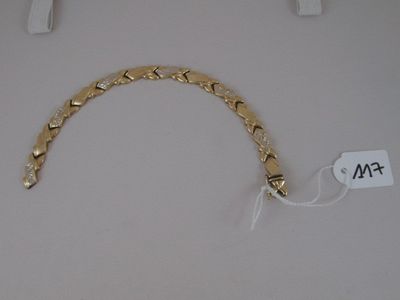a gold bracelet that is on display on a table