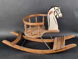 a wooden rocking horse with a rocking seat on it
