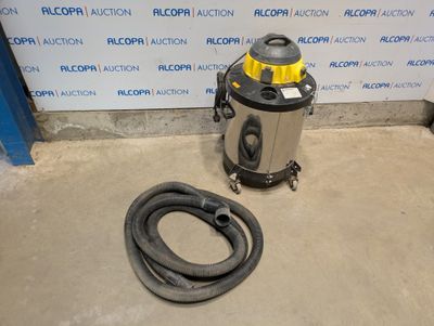 a vacuum and a hose on the floor in front of a wall