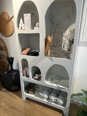 une étagère blanche sur laquelle sont posés de nombreux objets