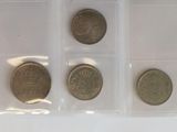 six different coins are in a plastic case on a white surface