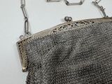 a silver purse with a chain hanging from it