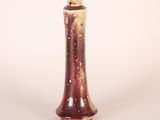 a brown and white vase sitting on a white surface