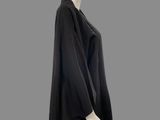 mannequin dressed in a black cape and leggings on a gray background