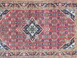 a red and blue rug with a diamond design on it