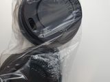 two black plastic cups wrapped in plastic on a white table