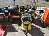 a yellow and black pressurer sitting on the ground next to other tools
