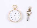 a gold pocket watch and a key on a white surface
