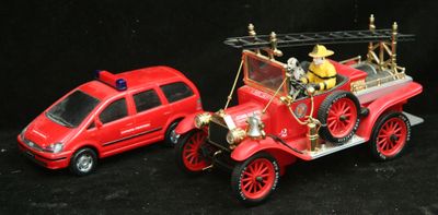 une petite voiture rouge et une autre petite voiture rouge sur fond noir