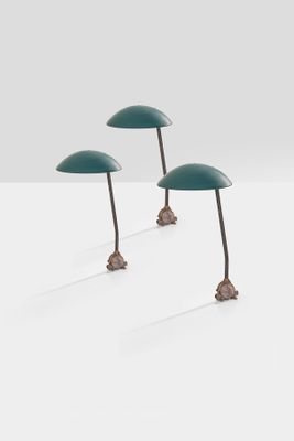 three green table lamps sitting on top of a white surface