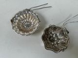 pair of silver plated flower ornaments on a white surface