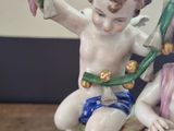 a figurine of a boy and a girl sitting on a rock