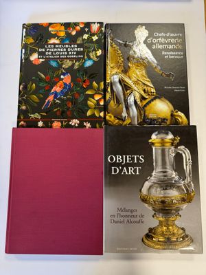 deux livres posés sur une table sur laquelle se trouve un vase