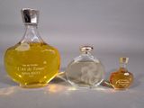 two bottles of perfume sitting next to each other on a table