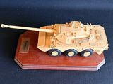 une petite maquette de char d'assaut posée sur un socle en bois