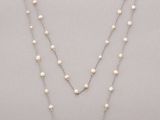 a white pearl and silver necklace on a silver chain