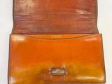 leather wallet with a metal clasp on a white surface