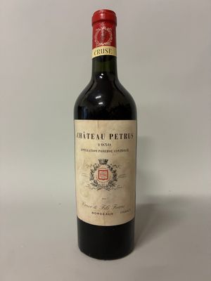 une bouteille de vin rouge posée sur une table blanche