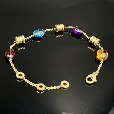 bracelet plaqué or orné de perles de verre multicolores sur un fond noir