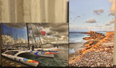 Deux photos de bateaux sont posées sur une étagère contre un mur.