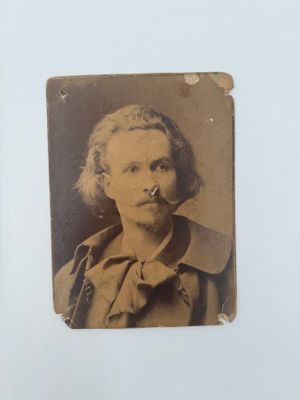 une vieille photo d'un homme avec une pipe à la bouche