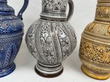 three different colored vases sitting next to each other on a table