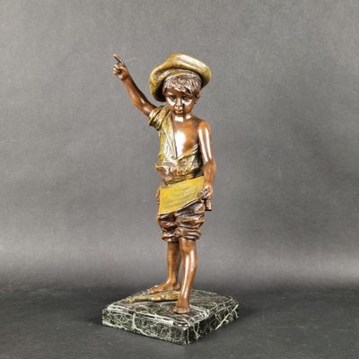 une statue en bronze représentant un garçon coiffé d'un chapeau, posée sur un socle en marbre