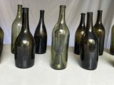 Plusieurs bouteilles de vin vides sont alignées sur une table