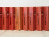six red books are lined up in a row on a white surface