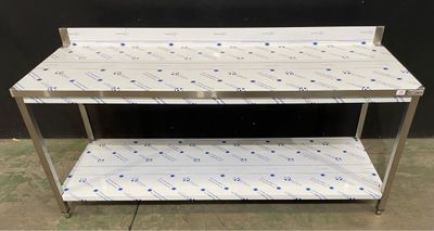 une table en acier inoxydable surmontée de deux étagères