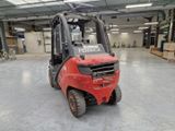 a red fork truck parked in a large warehouse