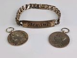 deux bracelets en argent et une pièce de monnaie sur laquelle est gravé un nom