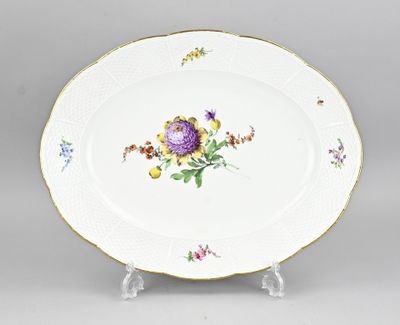 une image représentant une assiette décorée de fleurs, posée sur un support