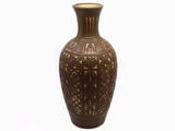 un vase brun posé sur une surface blanche