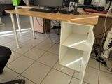 a desk with a computer on top of it in a room
