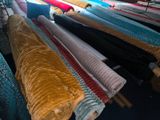 many rolls of fabric on a rack in a room