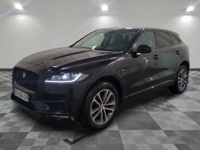 un SUV Jaguar noir garé sur un sol à damier dans un garage